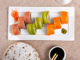Sushi set made of salmon, tuna and avocado dished up in service plate with soya-bean sauce