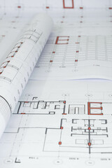 vertical view of rolled architectural and construction plans. Residential building design. Technical blueprints for projects