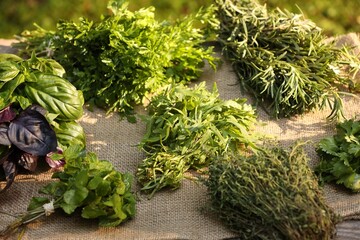 Different fresh herbs on table outdoors, closeup