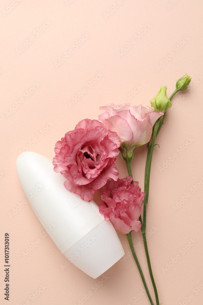 Poster Roll-on deodorant and beautiful eustoma flowers on beige background, flat lay