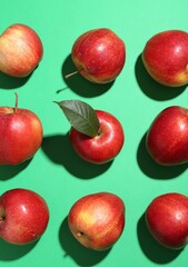 Red apples on green background, flat lay