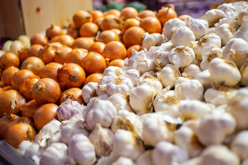 Garlic and onions on display at a grocery store