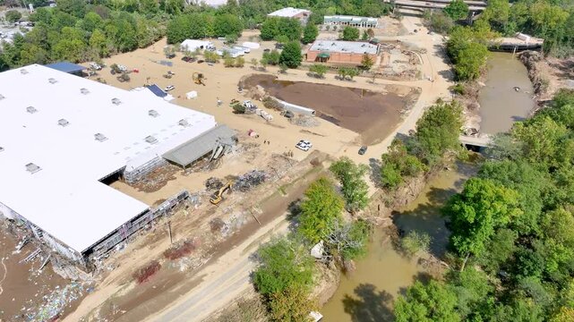 Aerial video of flooding damage and recovery one week after tropical storm Helene devastates Asheville, NC.