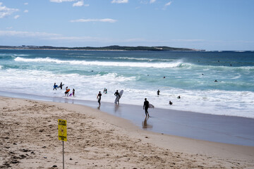 This image shows Cronulla Beach, Sydney, NSW, closed due to dangerous surf conditions, with large waves and warning signs. Despite the closure, surfers are still in the water, taking on the big waves  © Татьяна Мельникова