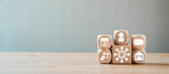 Wooden blocks displaying icons for omni channel communication and business strategy on a wooden table, symbolizing integrated customer experience.