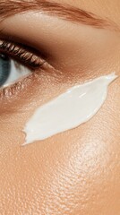 Fototapeta premium A high-resolution image of a woman applying anti-aging cream to her forehead to reduce wrinkles, with a neutral background and soft texture that emphasizes the face and skincare.
