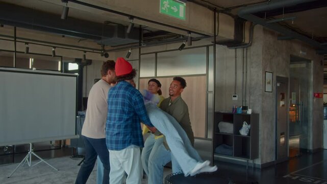 Multiracial team trains to trust catching coworker in office