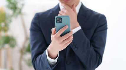 スーツを着た男性のスマートフォン