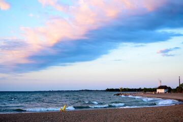 dramatic cloud over expansive beach with waves room for text shot on kew beach in toronto's beaches...