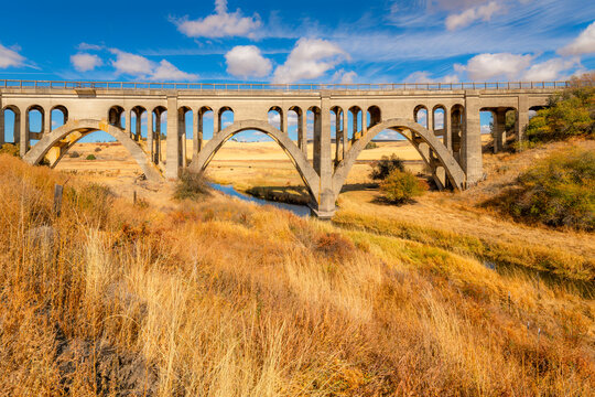 The concrete arch Rosalia Railroad Bridge built in 1915 crossing Pine Creek with the Steptoe Battlefield State Park behind, in the Palouse region of Rosalia Washington.