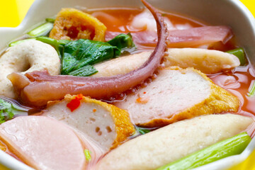 A bowl of pink flat noodles