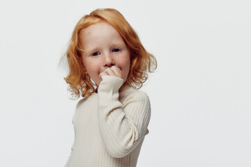 Redhaired girl covering mouth standing against white background innocence and beauty concept