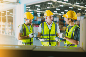 Three warehouse workers using a digital tablet while recording inventory. Logistics employees...
