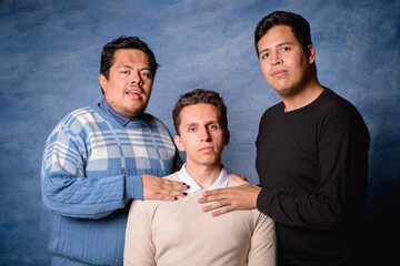 Group of 3 men in sweater on blue background in 90's yearbook style. Posing serious and romantic