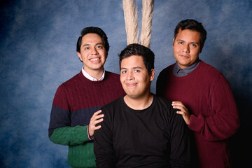 Group of 3 men in jersey on blue background in 90's yearbook style. Posing in an ironic way