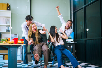 Four Asian friends, two men and two women, celebrate in an office party. They enjoy a fun-filled with food, drinks, and laughter, bonding over teamwork and friendship.