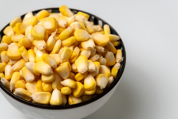pile of corn kernel in a white bowl, isolated on a white background