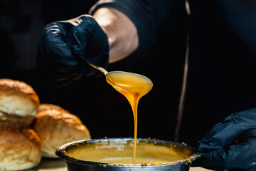 The chef is mixing a mayonnaise sauce for the burger and checking its texture