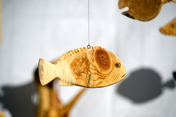 Close-up of detailed wooden fish carvings, expertly crafted and suspended - Powered by Adobe