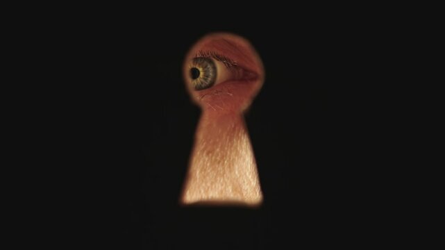 Male blue eye looking through the keyhole. The concept of voyeurism, curiosity, Stalker, surveillance and security
