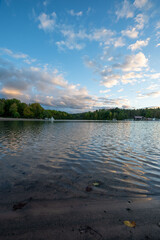 A serene sunset at Green Lakes State Park in Syracuse, New York, showcasing vibrant colors reflecting on the tranquil lakes surrounded by lush greenery. A perfect blend of nature’s beauty 