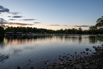A serene sunset at Green Lakes State Park in Syracuse, New York, showcasing vibrant colors reflecting on the tranquil lakes surrounded by lush greenery. A perfect blend of nature’s beauty 