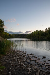 A serene sunset at Green Lakes State Park in Syracuse, New York, showcasing vibrant colors reflecting on the tranquil lakes surrounded by lush greenery. A perfect blend of nature’s beauty 