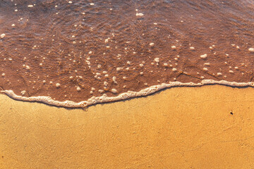 Soft wave of the sea on the sandy beach.