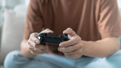 Young Asian man gamer controller video console playing holding hobby playful Online Video Game enjoyment eSport Cyber Games Internet.