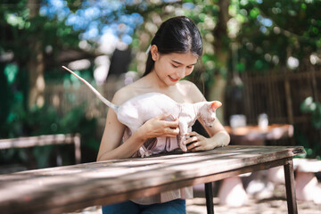 Smiling Beautiful asian young woman with Egyptian Sphynx cat Canadian Sphinx breed cat