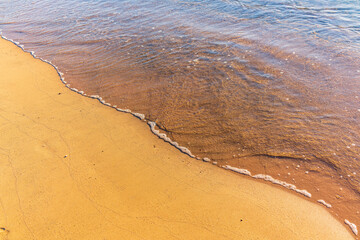 Soft wave of the sea on the sandy beach.