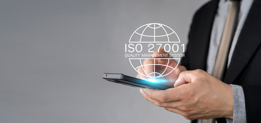 Businessman holding a tablet and showing a symbol ISO 2700, Information security management...