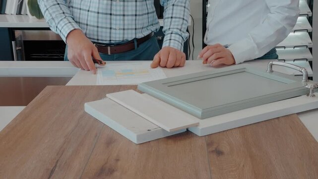 Two people selecting kitchen cabinet and countertop materials.