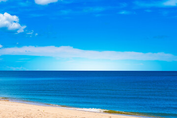 Fototapeta premium Nature of the beach and sea Summer with sunshine, sandy beaches, clear blue waters sparkling against the blue sky. On an island with good ecology and environment Background for summer vacation concept