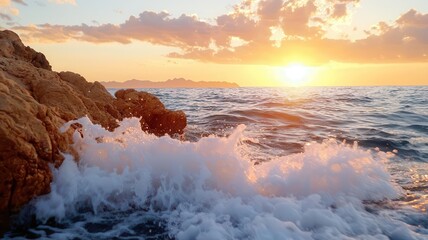 Obraz premium Sunset light illuminating waves crashing onto rugged coastal rocks, with orange and pink hues reflecting off the water