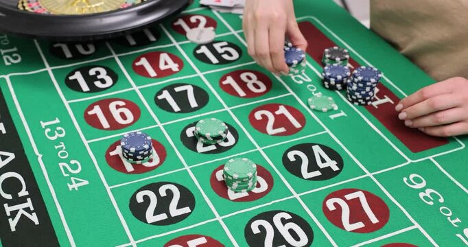 Woman hand takes stack of chips placing on green roulette table in casino. Enjoyable process of gambling offers excitement for avid players slow motion