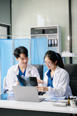 Doctors in lab coats discuss medication in a clinical setting, showcasing teamwork and collaboration