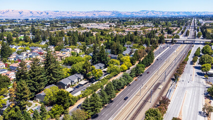 Aerial view of multi-lane road, with vehicles and train tracks between Central Expressway and Ellis Avenue in Mountain View, California surrounded by residential neighborhood