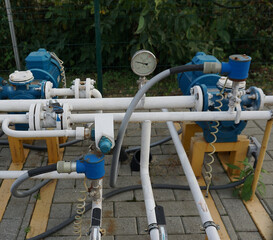 Natural gas pumping station among the spring fields. Yellow pipes, pressure gauges and valves - elements of the natural gas transmission installation .