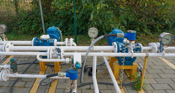 Natural gas pumping station among the spring fields. Yellow pipes, pressure gauges and valves - elements of the natural gas transmission installation .