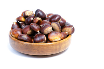 fresh seasonal chestnuts harvested in the field in a wooden bowl isolated on a white background and copy space