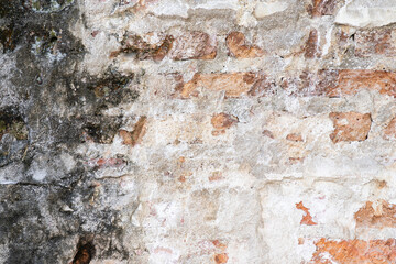 Empty Old Brick Wall Texture. Painted Distressed Wall Surface. Grungy Wide Brick wall. The texture of a very old vintage brick wall with residual elements of plaster decoration.