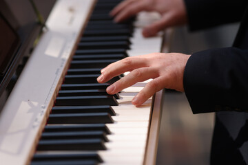 Obraz premium Details with the hands of a man playing an electric piano
