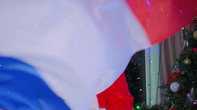 French flag in hands Santa dancing near glowing Christmas tree garlands, festive background for New Year party. Support team France.