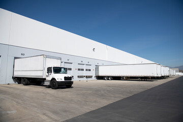 White box truck trailer parked at distribution warehouse bay