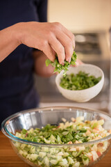Woman sprinkling lettuce in salad