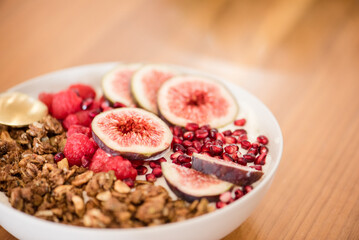 Yogurt with figs, pomegranate seeds, raspberries, and granola