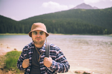 Fototapeta premium Young man standing near the lake and mountain