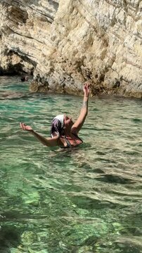 Vacation. Young woman swimming and bathing at sea rock lagoon.