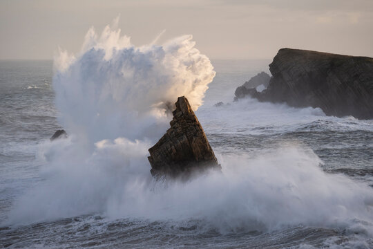 Large winter waves crash overy rocky coast, Playa de la Arnia, Spain